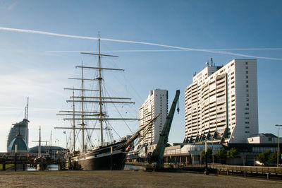 Sailboats in city against sky