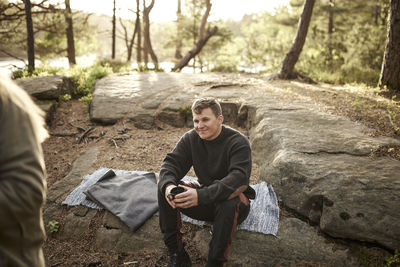 Smiling man drinking coffee outdoors