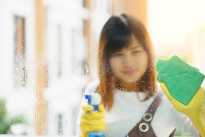 Portrait of woman looking through glass window