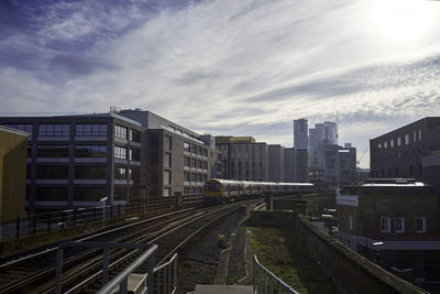 High angle view of railroad tracks amidst buildings against sky