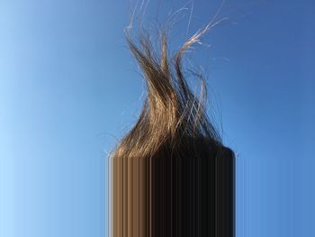 Close-up of metallic structure against blue sky