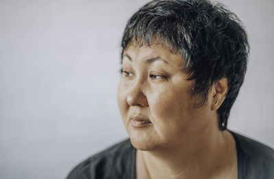 Asian woman of forty with a short haircut on a white background