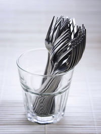 Stainless steel fork in drinking glass