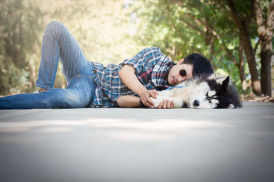 Low section of person with dog resting on sofa