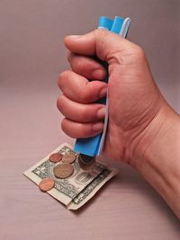 Cropped hand spilling coins over table 