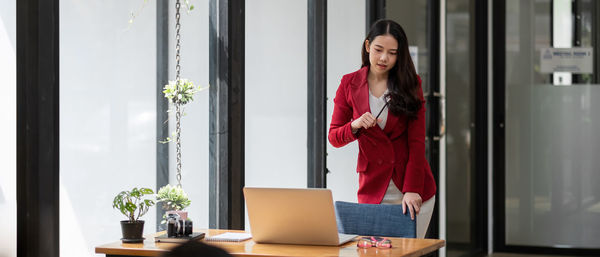 Young woman using phone while standing on table