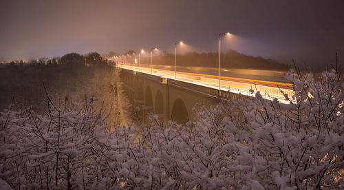 Train on snow covered railroad tracks against sky during winter