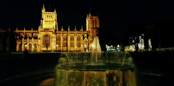 Statue in city at night