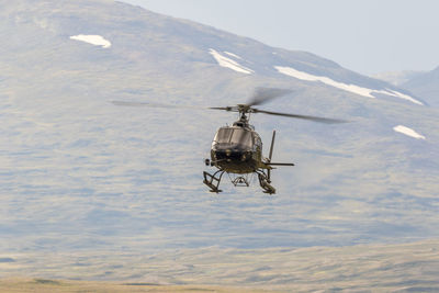 Helicopter flying in a mountain landscape in the wilderness