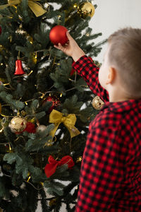 High angle view of boy standing by christmas tree