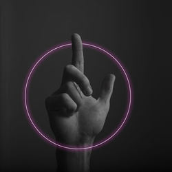 Digital composite image of person hand on illuminated lamp against black background