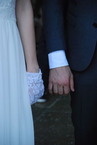 Midsection of couple holding hands