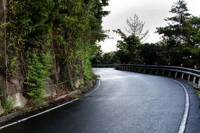 Empty country road by rock formation