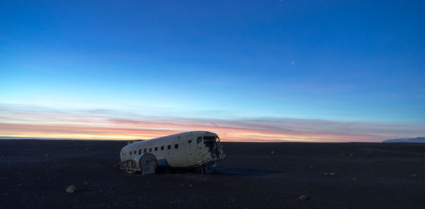 Abandoned airplane against sky during sunset