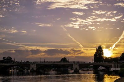 Arch bridge over river against sky in city