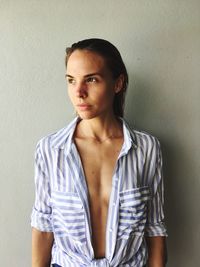 Portrait of young woman standing against white background