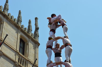 Low angle view of people against clear sky