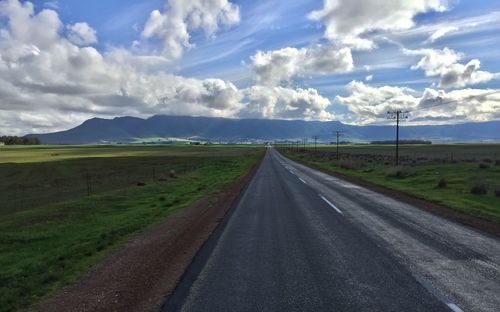 Road amidst field against sky
