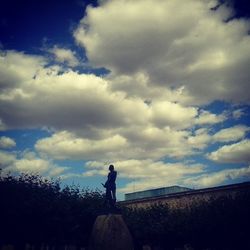 Silhouette of people against cloudy sky