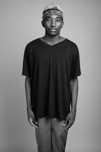 Portrait of young man standing against white background