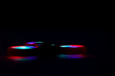 Close-up of illuminated fidget spinner against black background