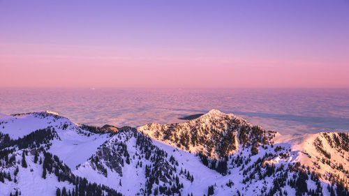 Scenic view of snow covered mountain against sky at sunset