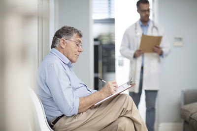 Patient filling in file in medical practice