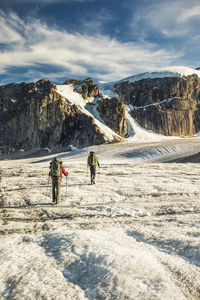 People on snowcapped mountain against sky