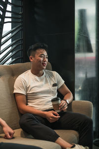 Young man sitting on sofa