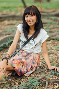 Portrait of young woman sitting on field