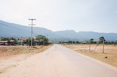 Empty road by land against sky