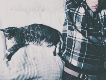Cropped image of man sleeping with cat on bed