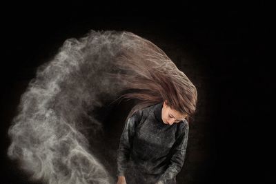 Portrait of a woman against black background