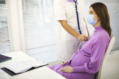 Midsection of doctor examining patient in office