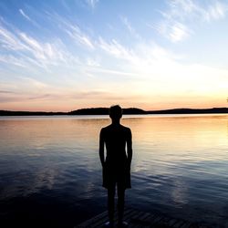 Silhouette of people standing by lake