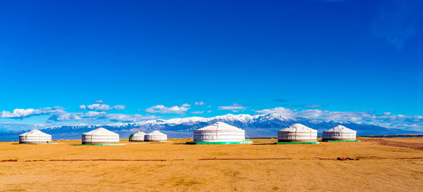 Built structures on field against clear blue sky