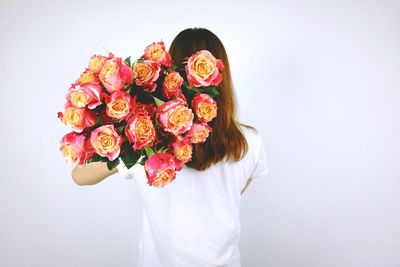 Rear view of women holding rose bouquet