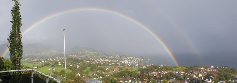 Scenic view of rainbow over buildings in city