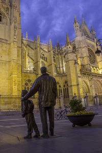 Rear view of man standing outside temple against sky