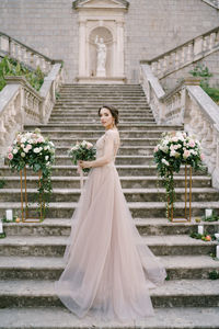 Woman standing by staircase outside building