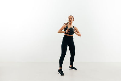 Full length of woman standing against white background