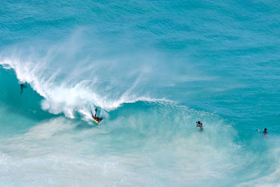 High angle view of people surfing in sea