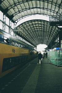 Rear view of woman standing on railroad station platform