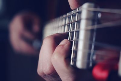 Cropped hands of person playing guitar