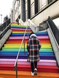 Rear view of woman standing against multi colored building