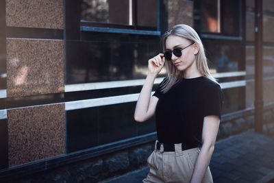 Young woman wearing sunglasses standing outdoors