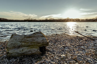 Close-up of frozen lake against sky during sunset