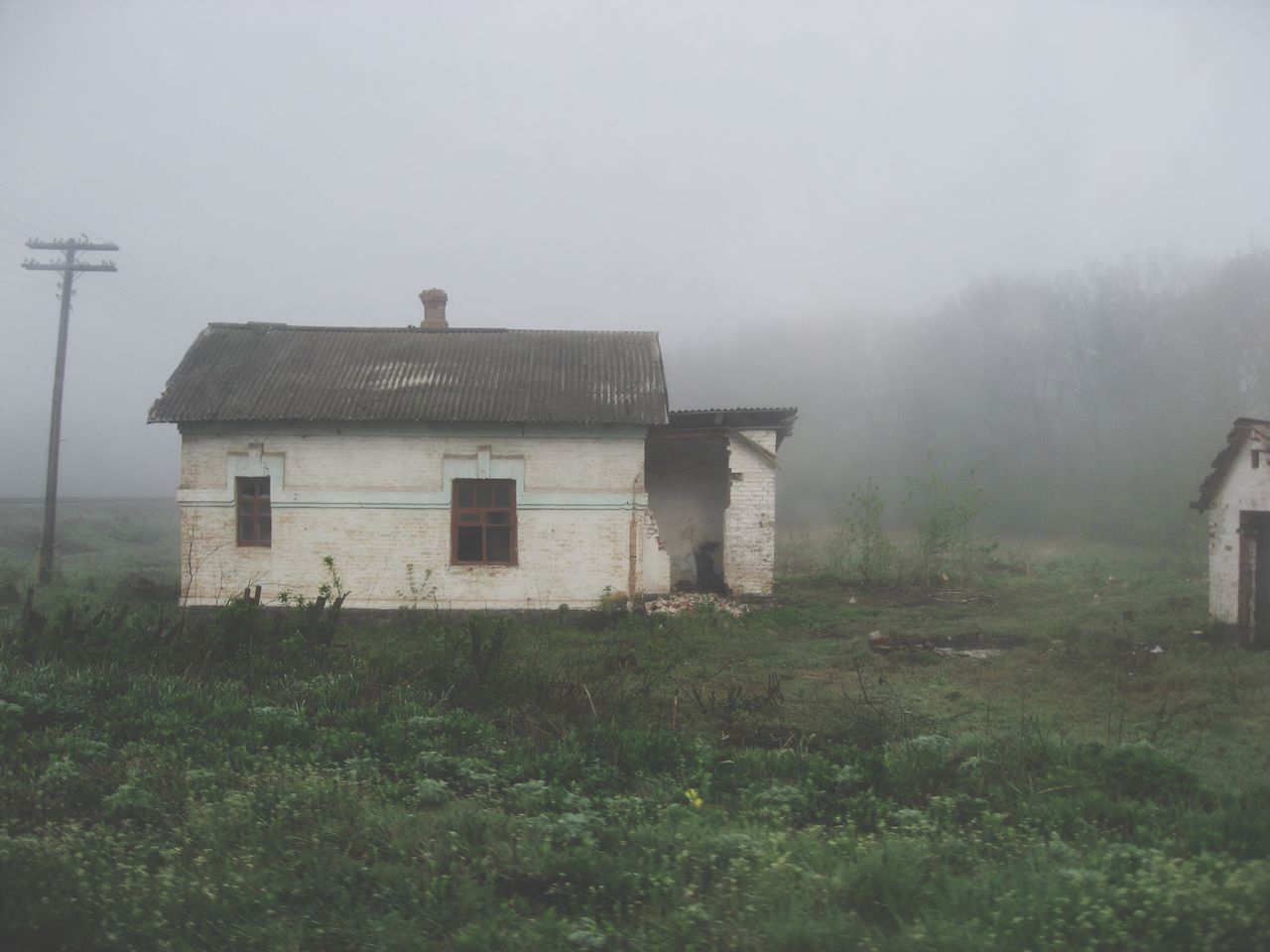 HOUSE ON FIELD AGAINST SKY IN FOGGY WEATHER