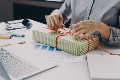 Midsection of woman packing gift