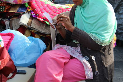 Woman sitting on chair and sewing